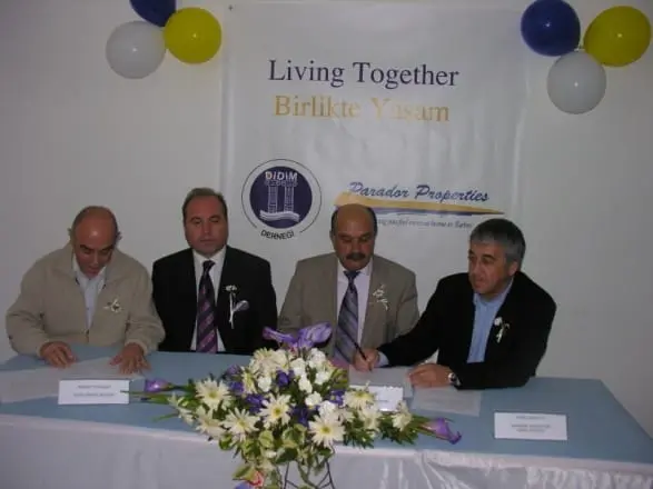 “Living Together · Birlikte Yaşam” pankartı altında protokol imzası