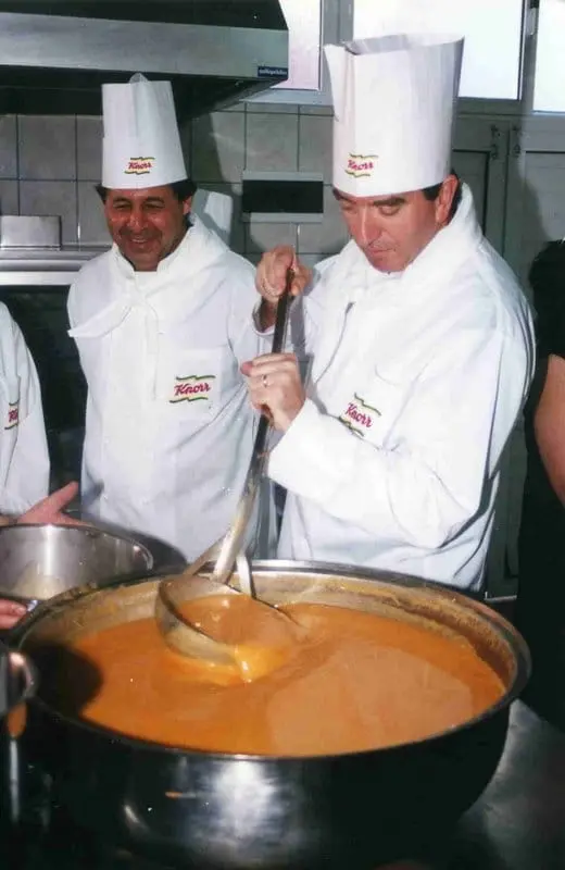 Knorr şapkalı iki aşçı büyük kazanda çorba karıştırıyor